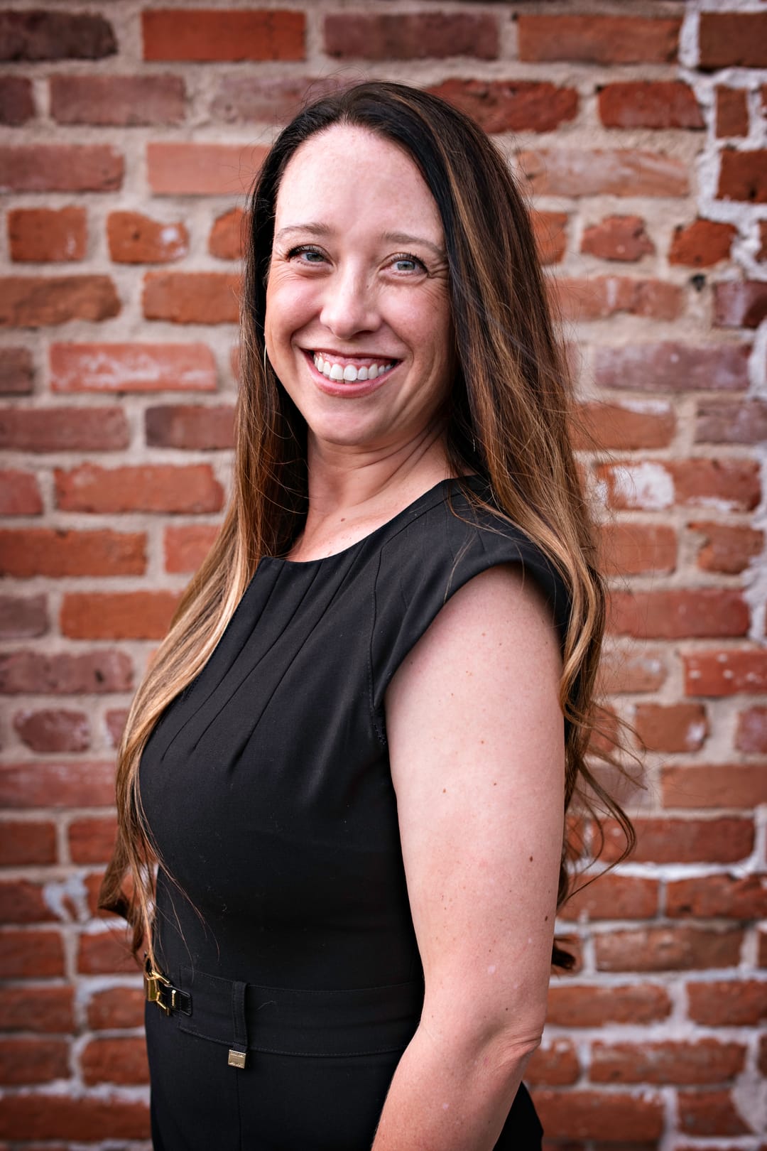 Stephanie Drobny smiling in front of a red brick wall